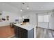 The kitchen features an island with seating, gray cabinets, quartz countertops, stainless steel appliances, and an open layout at 520 Blackbird Knoll Ct, North Las Vegas, NV 89084