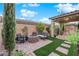 Cozy backyard with a paved patio, artificial turf, outdoor seating, and a fire pit at 5503 Jinan St, Las Vegas, NV 89148