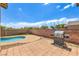 Backyard featuring a pool, BBQ, brick wall, and concrete patio area perfect for entertaining at 5528 Stone Lagoon St, North Las Vegas, NV 89031