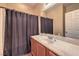 Bathroom featuring vanity with sink, large mirror, wood laminate floors, and shower with curtain at 5528 Stone Lagoon St, North Las Vegas, NV 89031