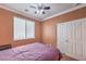 This bedroom features plush carpeting, a ceiling fan, a window with blinds, and a double door closet at 5528 Stone Lagoon St, North Las Vegas, NV 89031