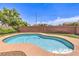 Backyard view of a refreshing pool with a surrounding patio area and privacy wall on a bright day at 5528 Stone Lagoon St, North Las Vegas, NV 89031