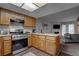 Functional kitchen with wooden cabinets, stainless steel appliances, and an open layout to the living room at 573 Sellers Pl, Henderson, NV 89011