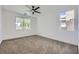 Bright bedroom featuring plush carpet, a ceiling fan, and natural light from two windows at 5834 Autumn Harvest Ave, Las Vegas, NV 89142