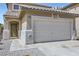 Close up of two-story home with a tile roof, a two-car garage, and neutral color scheme at 5834 Autumn Harvest Ave, Las Vegas, NV 89142