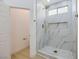 Modern walk-in shower featuring marble-style tile, gold trim, and a mosaic shower floor at 5834 Autumn Harvest Ave, Las Vegas, NV 89142