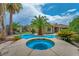 Inviting pool and hot tub with palm trees, offering a private backyard oasis at 5992 Quintillion Ave, Las Vegas, NV 89122