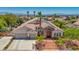 Aerial view of a home with solar panels, stone accents, three-car garage, and a landscaped front yard at 6140 Galileo Dr, Las Vegas, NV 89149