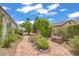 Charming backyard with flagstone path, mature trees, verdant landscaping, and cozy benches for relaxing at 6140 Galileo Dr, Las Vegas, NV 89149