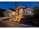 Stunning home featuring stone accents, a three-car garage, and illuminated step-up entrance with lush landscaping at 6140 Galileo Dr, Las Vegas, NV 89149