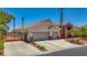 Charming home featuring a gated entrance, stone accents, a three-car garage, and beautifully landscaped front yard at 6140 Galileo Dr, Las Vegas, NV 89149