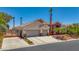 Lovely property with a gated entrance, stone accents, a three-car garage, and beautifully landscaped front yard at 6140 Galileo Dr, Las Vegas, NV 89149