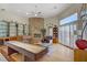 Open-concept living room with a stone fireplace, a ceiling fan, and a large window at 6140 Galileo Dr, Las Vegas, NV 89149