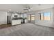 Open-concept living room featuring a bright kitchen and sliding glass doors at 6185 Blood Lily Ave, Las Vegas, NV 89122