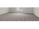 Spacious bedroom with plush carpet and a large window that provides natural light at 6197 Blood Lily Ave, Las Vegas, NV 89122