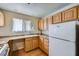 Well-lit kitchen with wooden cabinets, laminate countertops and a white refrigerator at 6766 Sebring St, Las Vegas, NV 89103