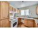 Functional kitchen with wood cabinets, white appliances, laminate countertops and wood-look flooring at 6766 Sebring St, Las Vegas, NV 89103