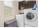Functional laundry room with modern washer and dryer units and storage at 6788 Sharks Bay Ct, Las Vegas, NV 89149