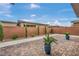 Landscaped backyard featuring brick pavers, manicured shrubs, and a concrete walkway at 6865 Steel Mist St, Las Vegas, NV 89148