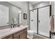 Bathroom with dark vanity, walk-in shower with glass doors, and modern fixtures at 6865 Steel Mist St, Las Vegas, NV 89148