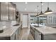 Modern kitchen with marble counters, island with sink, stainless appliances, and sliding glass doors to the patio at 6865 Steel Mist St, Las Vegas, NV 89148