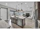 Open-concept kitchen with island and stainless steel appliances, flowing into the living area at 6865 Steel Mist St, Las Vegas, NV 89148