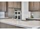 Close-up of a modern kitchen island with marble counters, stainless sink, and stylish faucet fixture at 6865 Steel Mist St, Las Vegas, NV 89148