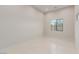Empty bedroom with neutral walls, tile flooring, base molding, and a large window at 7062 Maverick St, Las Vegas, NV 89131