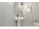 Simple powder room featuring a modern sink, round mirror, and neutral color palette at 7062 Maverick St, Las Vegas, NV 89131