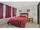 Cozy bedroom featuring a comfortable bed with burgundy bedding, bedside tables with lamps, and window with curtains at 7621 Hackensack Ct, Las Vegas, NV 89128