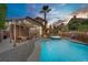 Backyard with a beautiful private pool, spa, covered patio, and desert landscaping at 7621 Hackensack Ct, Las Vegas, NV 89128
