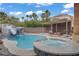 Resort-style pool features a water slide, waterfall, and hot tub for ultimate backyard fun and relaxation at 7621 Hackensack Ct, Las Vegas, NV 89128
