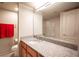 Well-lit bathroom with granite countertop, framed mirror, and tiled shower, offering a functional design at 794 Oakmont Ave # 106, Las Vegas, NV 89109