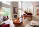 Bright living room boasts a stone fireplace, hardwood floors, and a grand piano, creating a stylish atmosphere at 794 Oakmont Ave # 106, Las Vegas, NV 89109