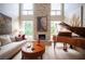 Bright living room with stone fireplace, large windows, grand piano, and comfortable seating at 794 Oakmont Ave # 106, Las Vegas, NV 89109