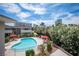 Community pool with lounge chairs and tables, surrounded by flowering bushes, set against a skyline backdrop at 794 Oakmont Ave # 106, Las Vegas, NV 89109
