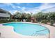 Relaxing community pool with lounge chairs, surrounded by lush landscaping and a clear blue sky at 794 Oakmont Ave # 106, Las Vegas, NV 89109