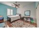 Well-lit bedroom boasts sleek dark wood floors, a plush rug, and a tranquil blue accent wall at 8216 Tursi Lodge Ct, Las Vegas, NV 89131
