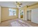 Spacious carpeted bedroom features a ceiling fan, archway, and large window at 8231 Burnt Sienna St, Las Vegas, NV 89123