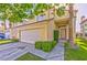 Inviting home featuring a two-car garage, green shrubbery and well maintained lawn at 8231 Burnt Sienna St, Las Vegas, NV 89123