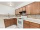Updated kitchen with white appliances, wood cabinets, and a stylish tile backsplash at 848 Hedge Way # 5, Las Vegas, NV 89110