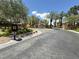 Welcoming community entrance with well-manicured landscaping, signage, and palm trees at 8612 Chiquita Dr, Las Vegas, NV 89128