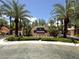Elegant community entrance with lush landscaping and a prominent sign, framed by palm trees at 8612 Chiquita Dr, Las Vegas, NV 89128