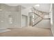 The airy living room features soaring ceilings, stairs and a neutral color palette throughout at 8612 Chiquita Dr, Las Vegas, NV 89128