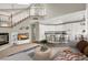 Bright, open-concept living room features a fireplace, staircase, and views into the modern kitchen at 8612 Chiquita Dr, Las Vegas, NV 89128