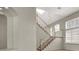 Elegant staircase with wood railings and white spindles, bathed in natural light from a skylight at 8612 Chiquita Dr, Las Vegas, NV 89128