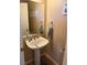 Updated half bath features a pedestal sink, framed mirror, and bronze fixtures at 9709 Port Orange Ln, Las Vegas, NV 89134