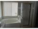 Bathroom featuring soaking tub with shower and window at 9709 Port Orange Ln, Las Vegas, NV 89134