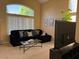 Cozy living room with large windows, comfortable seating, and a television at 9709 Port Orange Ln, Las Vegas, NV 89134