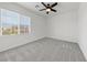 Bright bedroom with large window, ceiling fan and neutral carpet at 9839 Berkley Brook Ct, Las Vegas, NV 89141